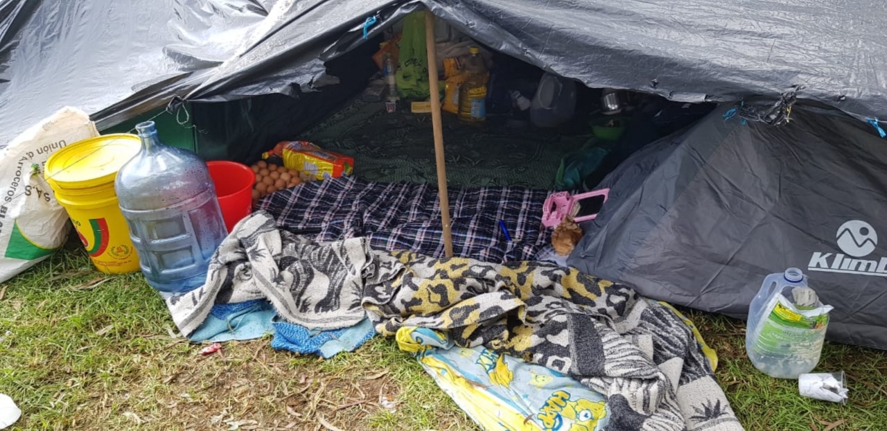 Las viviendas improvisadas por venezolanos a las afueras del terminal|Asentamiento venezolana al costado sur de la Terminal de Trasporte|Personas con su equipaje en la Terminal|Rixon y Kriseni con su hijo, una de las familias que se han registrado con el PEP (permiso especial de permanencia)|Jornada de ayuda a los migrantes|Jóvenes venezolanos charlando con un periodista en zonas aledañas a la terminal|Madre venezolana con su hijo a las afueras del Terminal de Transportes|Terminal de Transportes de Bogotá, lugar de llegada y asentamiento de los venezolanos que llegan desde Cúcuta y diferentes ciudades del país.|||