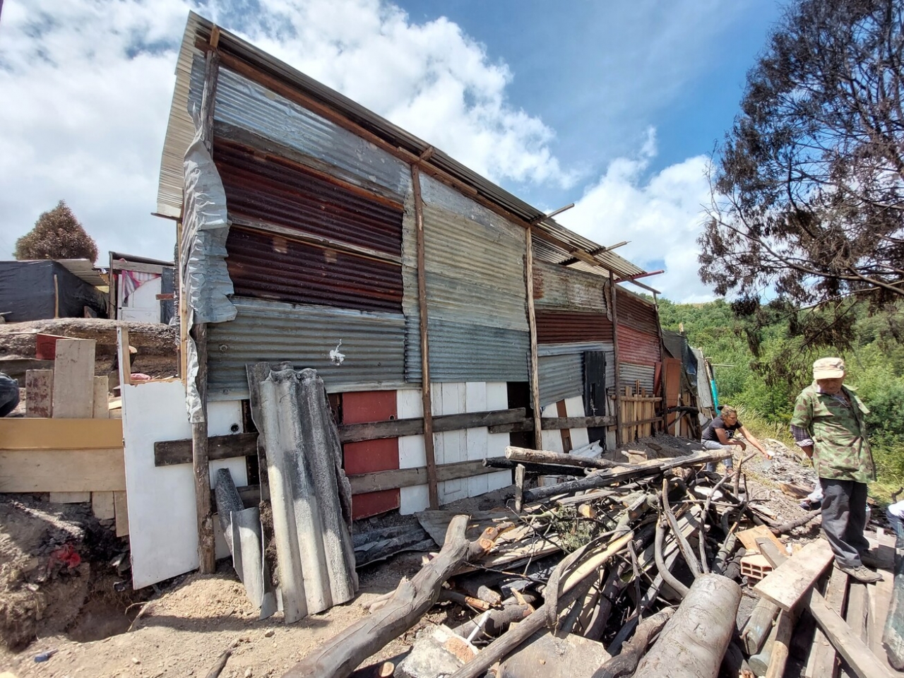 Lote quemado en porceso de reconstrucción|Sector afectado a la derecha y vecindario a la izquierda|Hombre y niña trabajan en la reconstrucción de su hogar|Proceso de trabajo|Sillón residuo del incendio|Retrato Fabián Forero|Retrato María Isabel Beltrán|Retrato Pedro Duzán|Retrato Víctor Barreto|Fabián Forero dirige la reconstrucción del lote de sus familiares|||