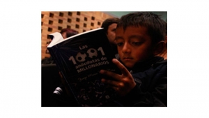 Niños y adultos leen de futbol.|||