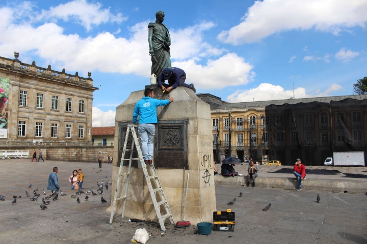 Miembros de la Alcald&iacute;a tratando de limpiar el monumento a Sim&oacute;n Bol&iacute;var.