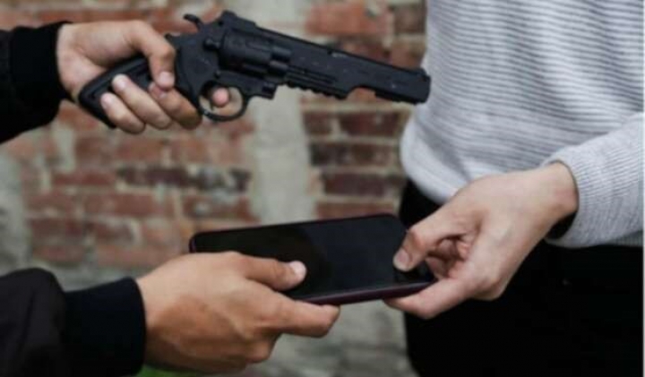 Ladr&oacute;n apunt&aacute;ndole a una mujer.