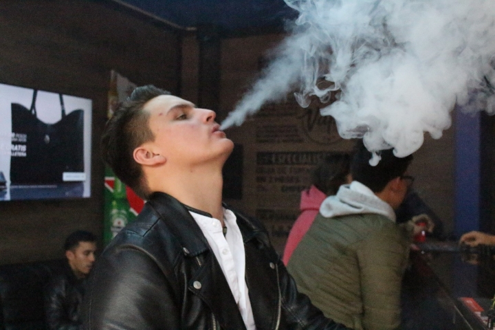Joven vapea en &acute;Vapor kingdom&acute;, tienda de cigarrillos electr&oacute;nicos.