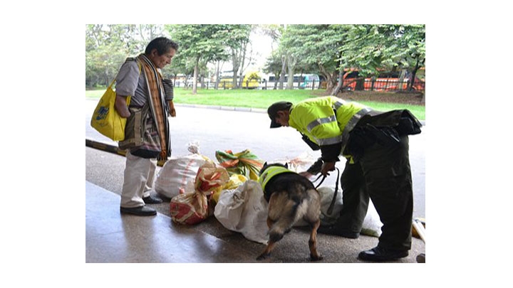 Patrullero Wilmer Yessid S&aacute;nchez hace inspecci&oacute;n con el canino Danger en Semana Santa en el terminal del Salitre en Bogot&aacute;.