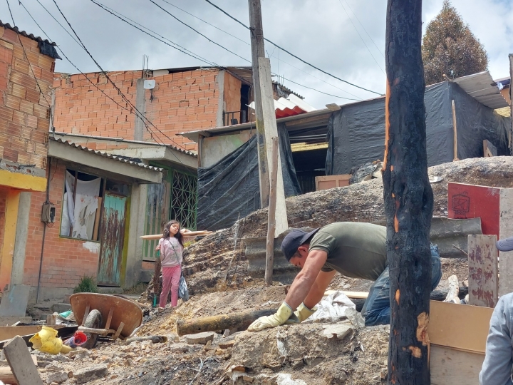 Hombre y ni&ntilde;a trabajan en la reconstrucci&oacute;n de su hogar