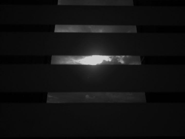 &ldquo;El otro lado". El cielo se ve desde las ventanas de las casas, se vive desde una perspectiva muy oscura, sin poder salir. Se restringe el otro lado de la ventana.