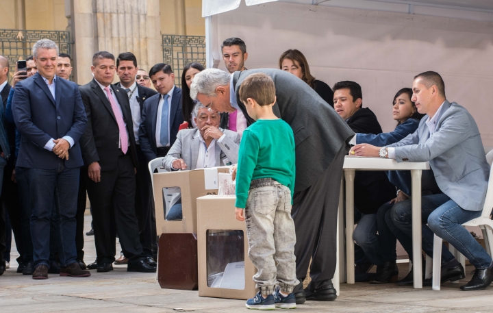 El expresidente y senador &Aacute;lvaro Uribe V&eacute;lez votando en compa&ntilde;&iacute;a de su nieto. Foto: Juli&aacute;n R&iacute;os